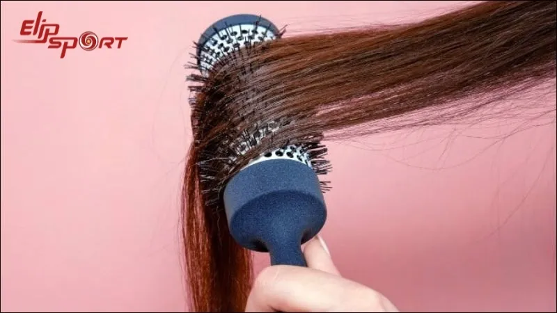 Đặt đuôi tóc cụp vào thân lược đầu tròn để chuẩn bị sấy