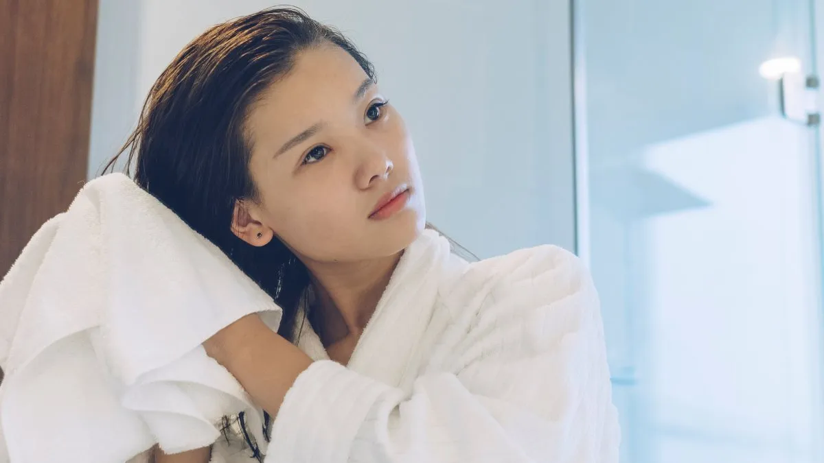 Dùng khăn làm khô tóc trước là bước chuẩn bị quan trọng trong mẹo sấy tóc nữ