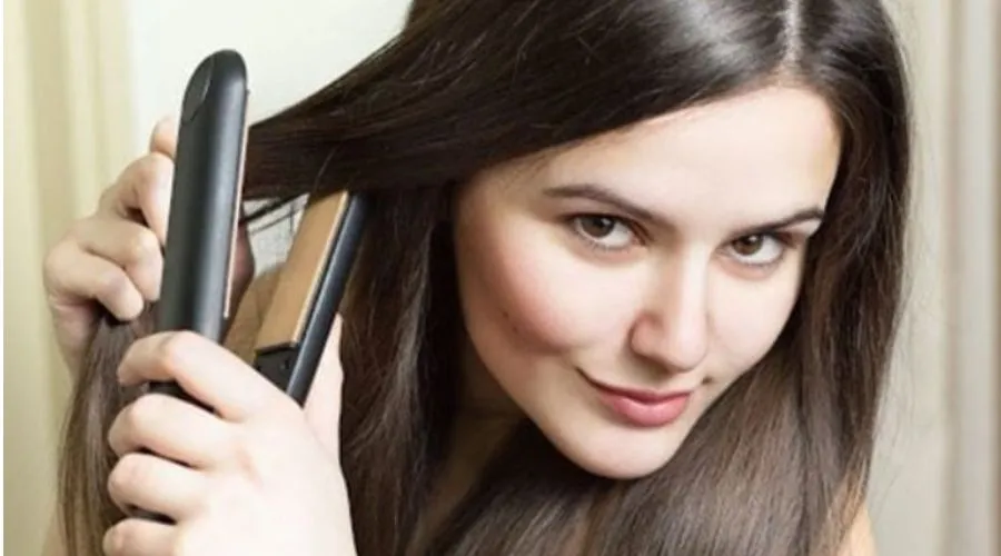 Người dùng đang điều chỉnh nhiệt độ của máy duỗi tóc mini theo mức nhiệt khuyến nghị cho từng loại tóc khác nhau