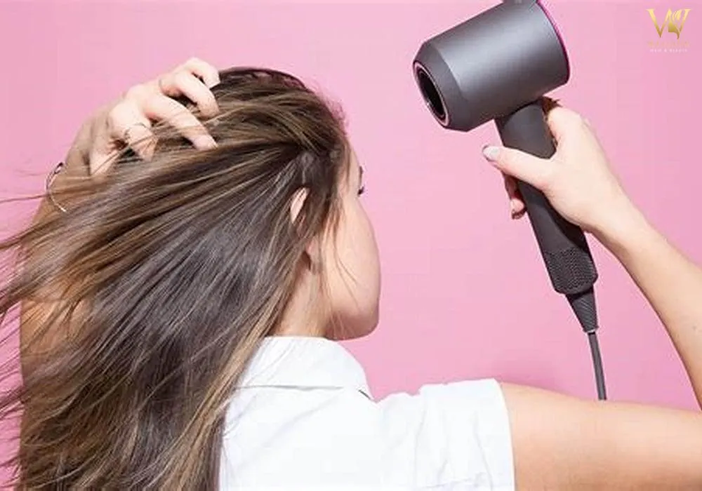 Sấy tóc đúng cách với lược tròn và điều chỉnh nhiệt độ thích hợp là bước cơ bản để giữ nếp thẳng cho tóc mái