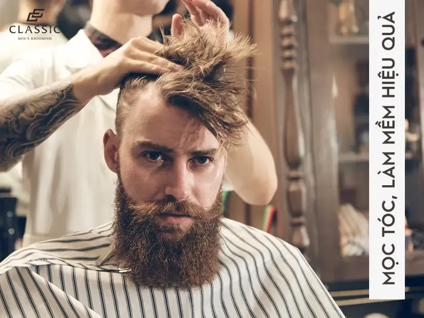 Hình ảnh người phụ nữ đang vuốt nhẹ tinh dầu Moroccanoil lên phần ngọn tóc khô để tăng độ bóng và giảm xơ rối