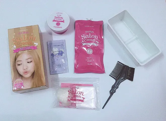 Hình ảnh các dụng cụ cần thiết để tẩy tóc tại nhà, bao gồm bát trộn, cọ và găng tay