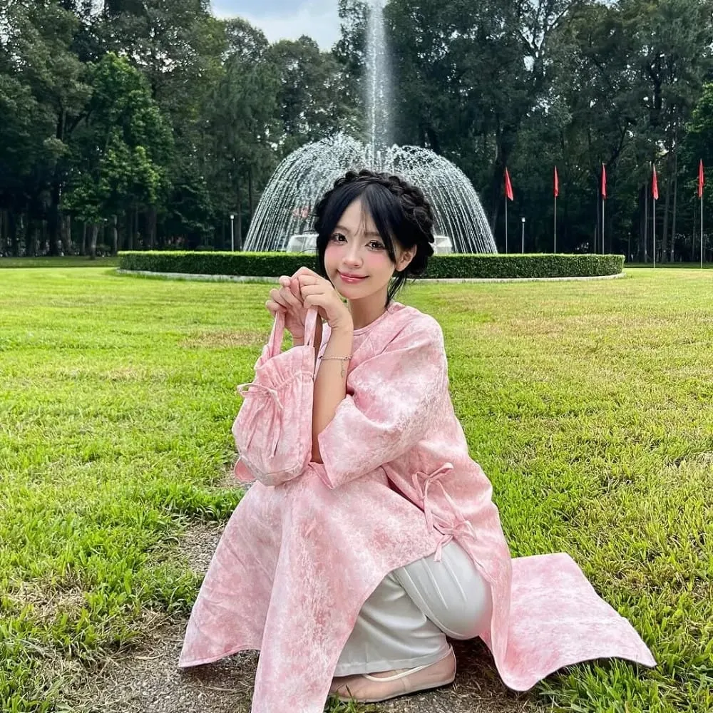 Cô gái duyên dáng với mái tóc tết vòng nguyệt quế tinh tế, toát lên vẻ đẹp chuẩn nàng thơ Áo Dài