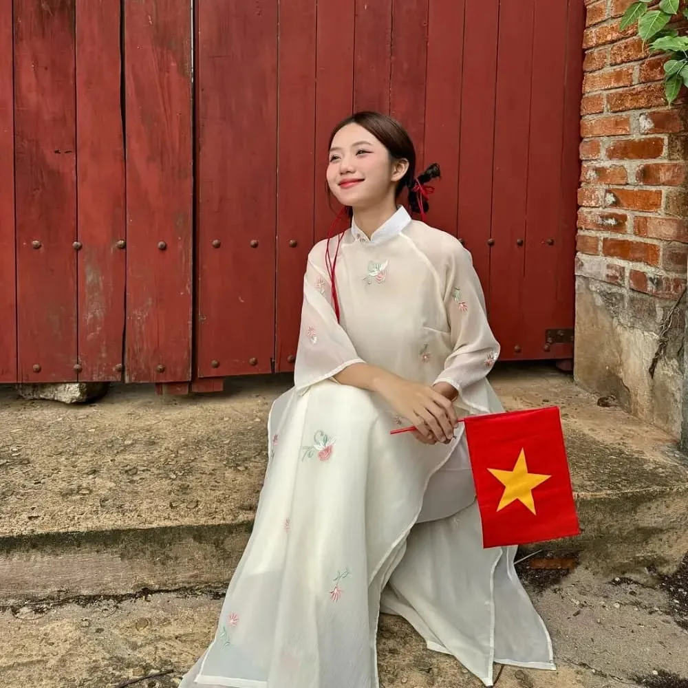 Tạo kiểu tóc tết búi thấp tinh tế, phối hợp hoàn hảo với áo dài trắng thanh lịch, phù hợp cho cách tết tóc đẹp mặc áo dài