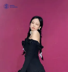 Dây ruy băng giúp Jennie làm nổi bật mái tóc và trang phục tối màu