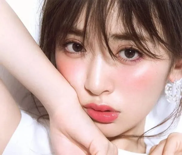 Một phụ nữ với kiểu trang điểm ngọt ngào, tôn nét tự nhiên, kết hợp tóc tết đuôi cá dịu dàng