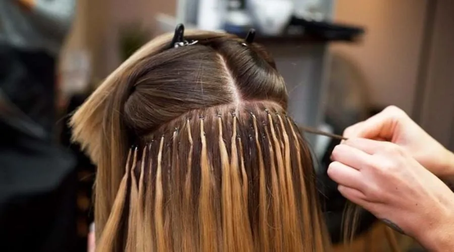 Bàn tay đang thực hiện thao tác tết tóc, có thể liên quan đến phương pháp nối tết tóc cho độ bền cao