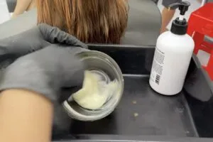 Chuyên gia tóc đang pha chế công thức thuốc uốn gợn sóng nóng an toàn và chính xác