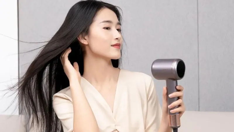 Người phụ nữ đang cầm máy sấy tóc và tạo kiểu cho mái tóc dày