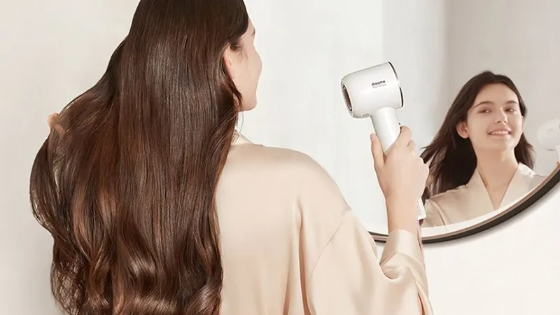 Người phụ nữ tạo kiểu tóc bồng bềnh bằng lược tròn và máy sấy tóc