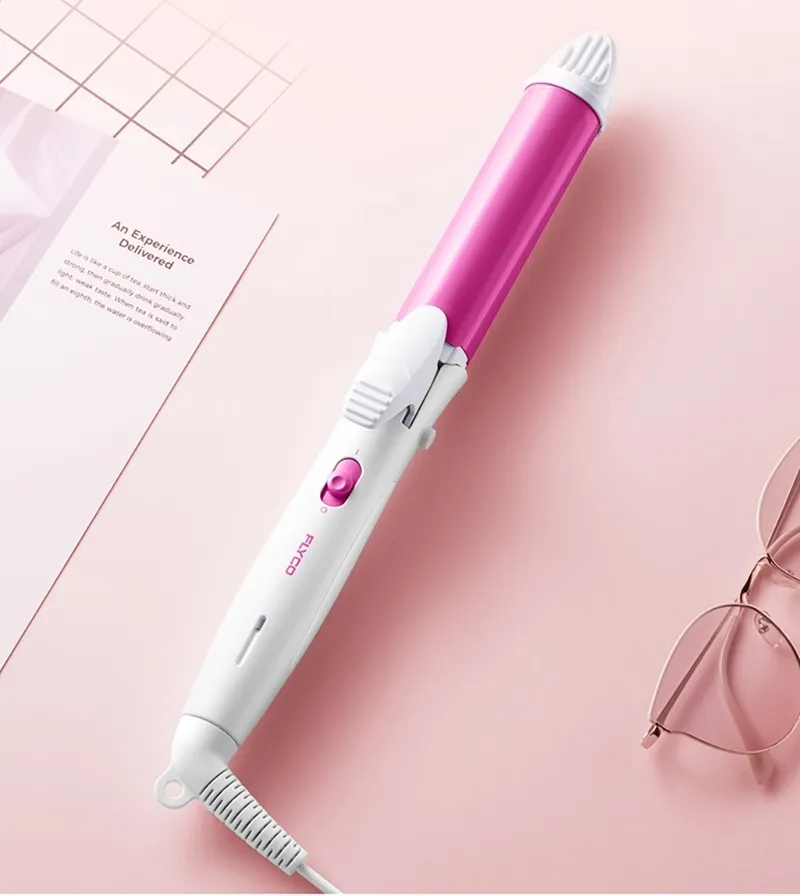 Một lọn tóc đang được kẹp giữa hai bản kẹp nóng của máy duỗi tóc