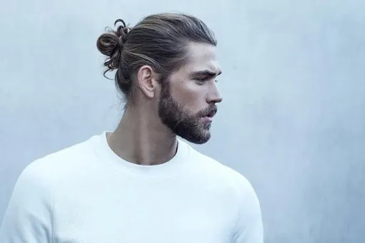 Một người đàn ông với kiểu búi tóc Man Bun gọn gàng, tạo vẻ ngoài cá tính và ngầu