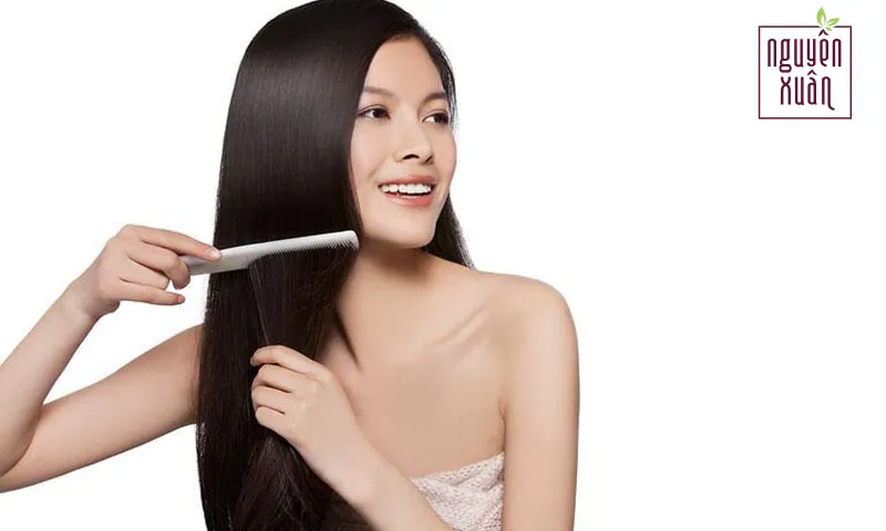 Hình ảnh một người đang chăm sóc tóc, minh họa việc giữ tóc thẳng tự nhiên