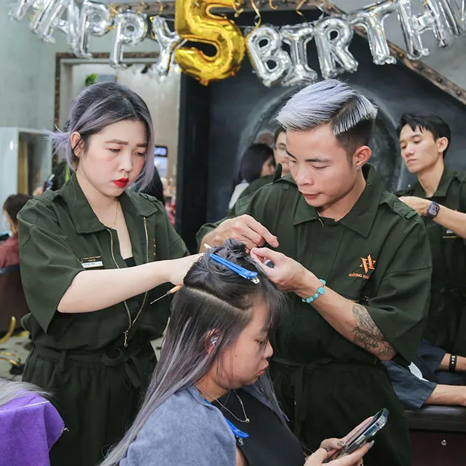 Người phụ nữ đang gội đầu chuẩn bị cho quá trình nối tóc bằng sợi fiberglass