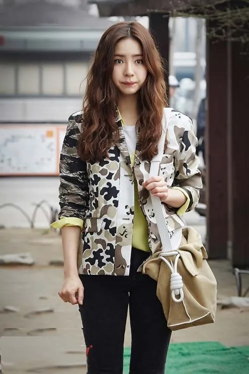 Tóc dài uốn xoăn nhẹ, mái xéo giúp kéo dài và làm thon gọn khuôn mặt tròn