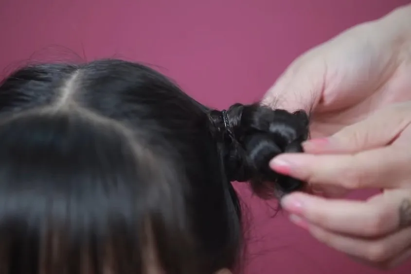 Cuộn tóc bím lại thành búi và cố định bằng thun