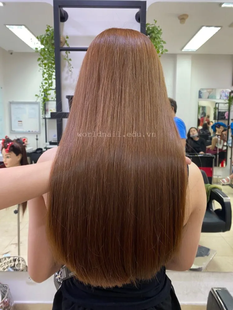 Một phụ nữ đang thoa hỗn hợp dưỡng chất từ thiên nhiên, một bước trong cách làm tóc xoăn duỗi thẳng