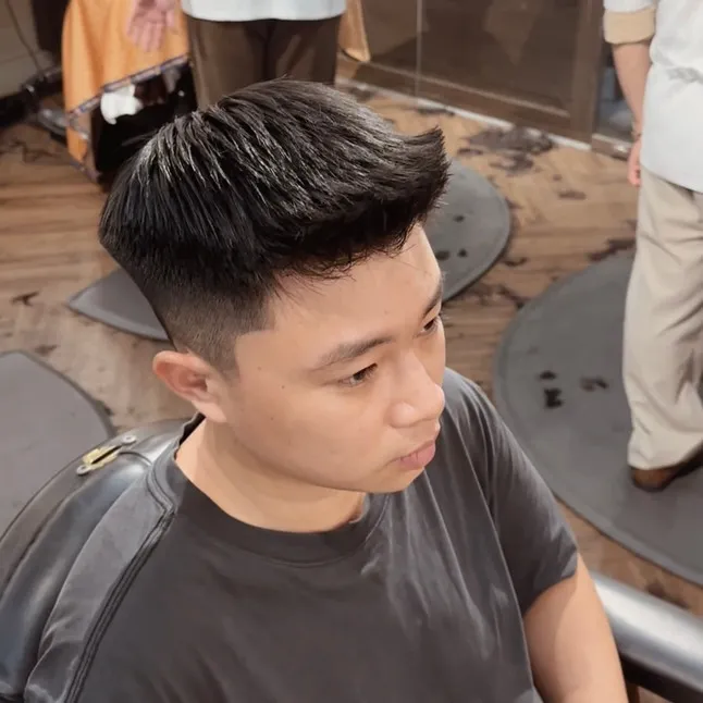 Một người đàn ông trẻ với mái tóc textured cut, kiểu tóc tận dụng độ cứng cáp tự nhiên