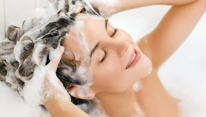 Người phụ nữ đang gội đầu tại nhà để làm sạch phần tóc mái