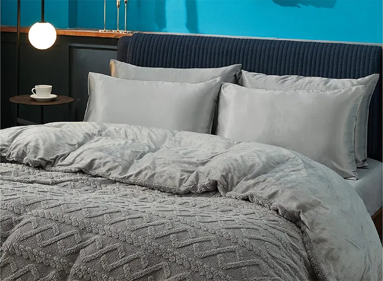 Một chiếc gối satin màu xám đặt trên giường, chất liệu mịn màng, bóng