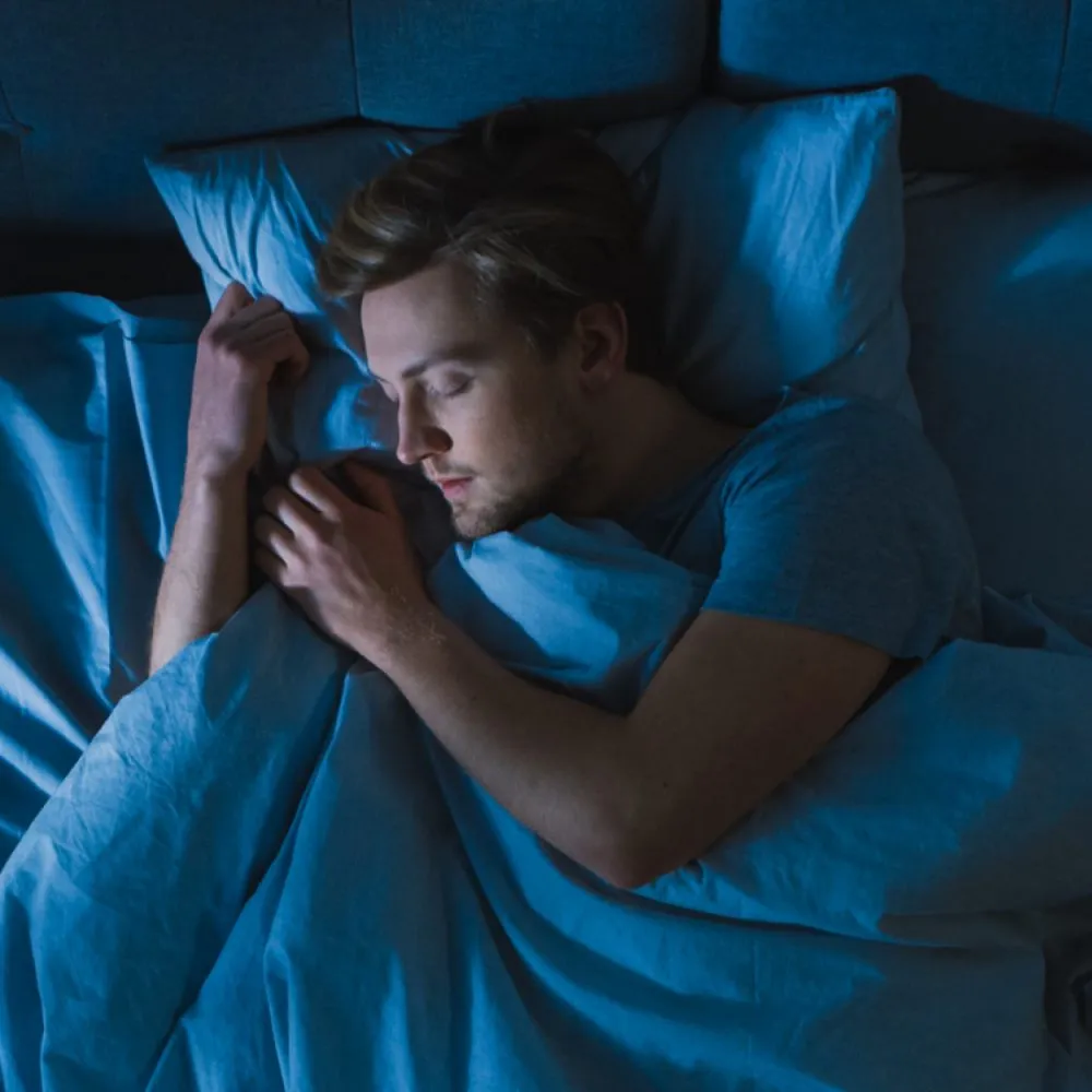 Hình ảnh người đàn ông đang ngủ sâu hoặc đang thư giãn, nhấn mạnh tầm quan trọng của giấc ngủ và nghỉ ngơi
