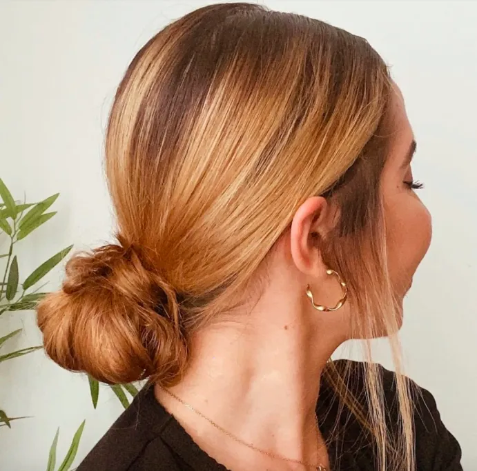 Kiểu tóc búi củ tỏi thấp lỏng lẻo, tạo độ phồng tự nhiên trên đỉnh đầu, mang lại vẻ ngoài trẻ trung