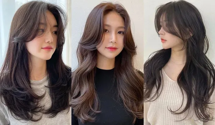 Một cô gái đang tự cắt tóc mái bay tại nhà với chiếc kéo và kẹp tóc