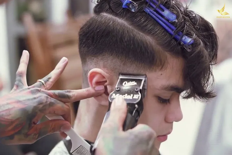 Thao tác cắt viền tóc ở vùng thái dương bằng tông đơ viền