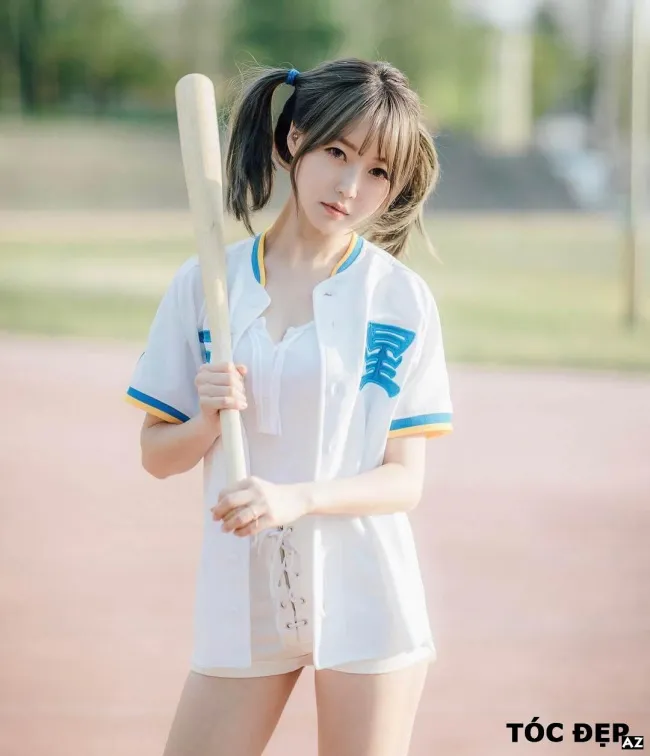 Cô gái với mái tóc đen thẳng dài được buộc hai bên cao gọn gàng, tạo vẻ ngoài trẻ trung và cá tính