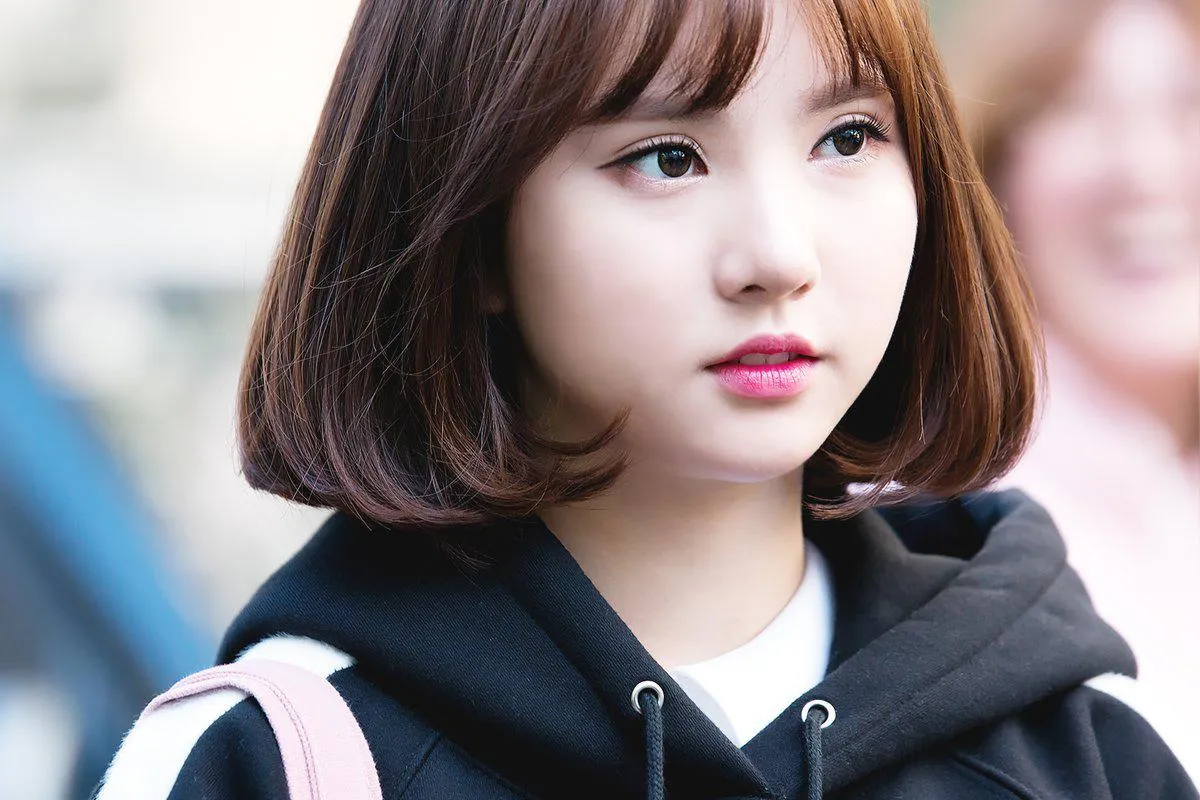 Người mẫu nữ có mái tóc ngắn uốn cụp cơ bản, tạo vẻ ngoài trẻ trung và thanh lịch.