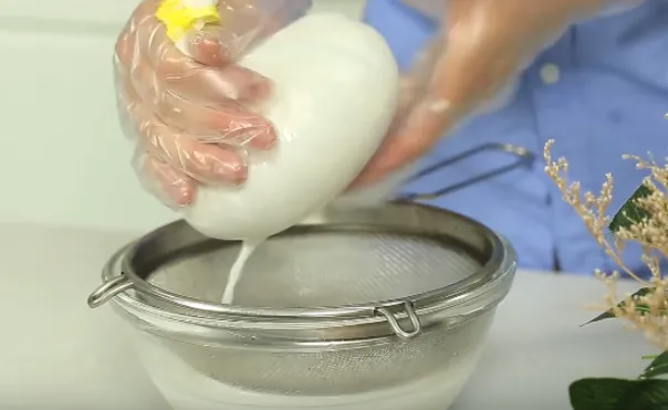 Mô tả hình ảnh: Cảnh quay gần nồi nấu đang chứa cốt dừa sệt, với nhiệt độ thấp để tách tinh dầu dừa nguyên chất