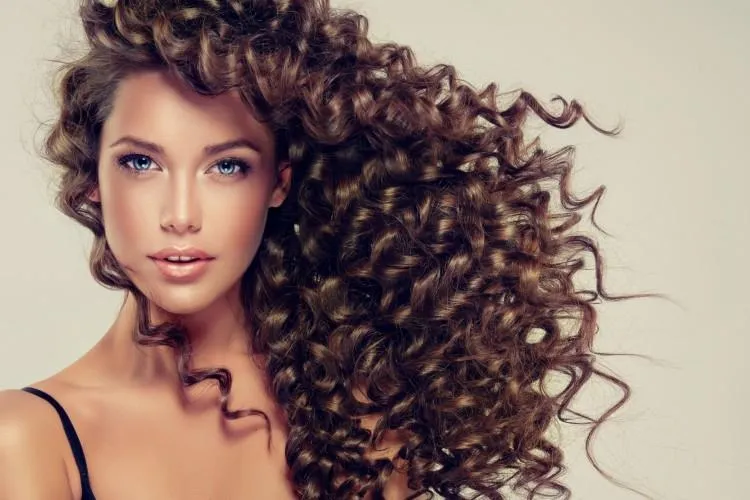 Người phụ nữ đang uốn tóc bằng cách tết bím tóc vào ban đêm để tạo lọn xoăn không nhiệt