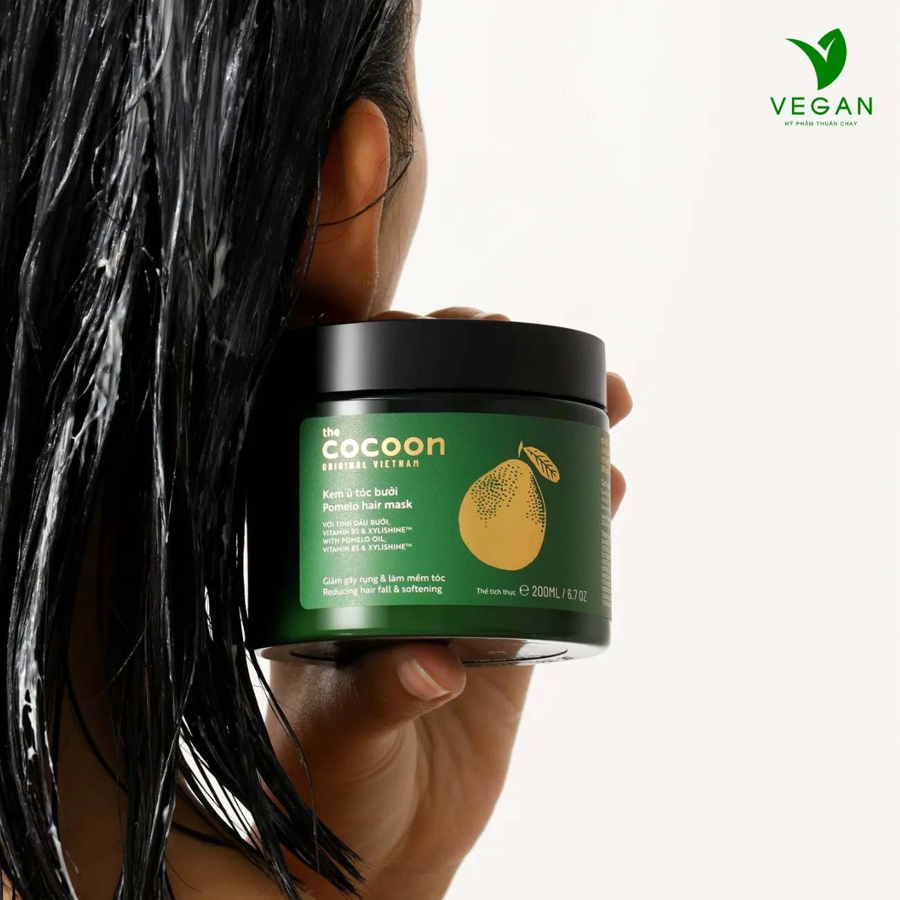 Mô tả một lượng kem ủ tóc Pomelo Cocoon vừa đủ đang được lấy ra trên tay để thoa lên tóc