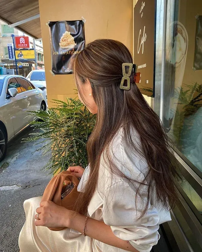 Tóc buộc nửa đầu tạo độ phồng và cố định bằng kẹp càng cua tạo vẻ đẹp ngọt ngào, lãng mạn.