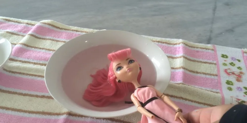 Ngâm tóc búp bê vào dung dịch nước xả vải đã pha loãng