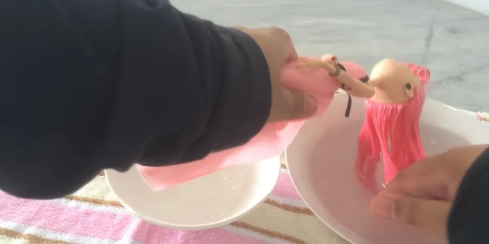 Dùng tay massage nhẹ nhàng để loại bỏ bụi bẩn trên tóc búp bê