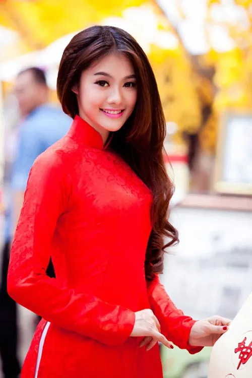 Tóc dài xoăn sóng lơi kết hợp áo dài trắng, tạo vẻ nữ tính, mềm mại thanh lịch