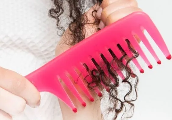 Sử dụng lược răng thưa chuyên dụng để gỡ rối các lọn tóc xoăn một cách nhẹ nhàng