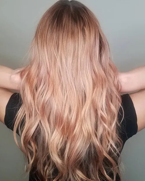 Cô gái có mái tóc dài uốn lượn, nhuộm tông vàng ánh hồng