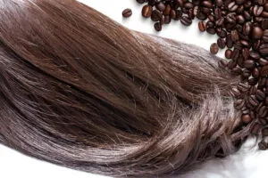 Đổ cà phê đậm đặc đã nguội vào bát trộn cùng dầu xả và mật ong để chuẩn bị cho quá trình nhuộm tóc bằng nguyên liệu tự nhiên