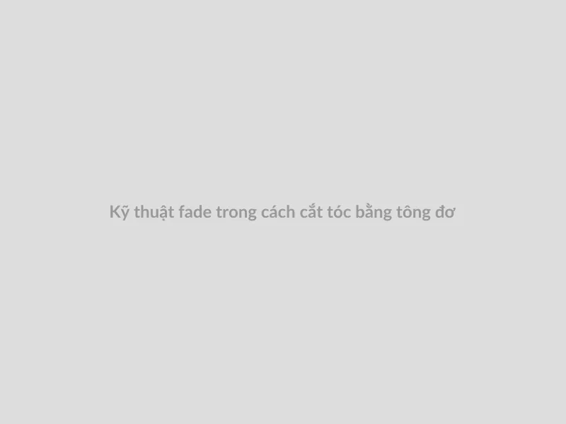 Một thợ cắt tóc đang thực hiện kỹ thuật fade (cắt phân tầng) ở khu vực thái dương