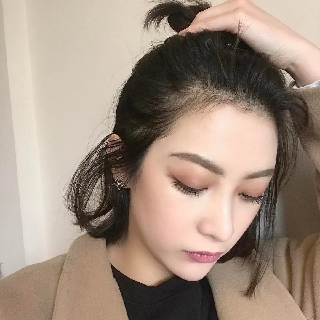 Người mẫu tóc ngắn uốn cụp, buộc tóc nửa đầu cao tạo vẻ ngoài tươi tắn, năng động