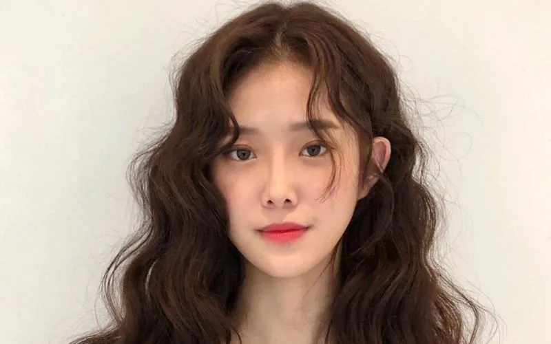 Tóc mái xoăn có thể do di truyền hoặc do thiếu hụt Keratin, khiến tóc dễ hấp thụ độ ẩm và bị xoăn