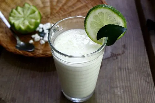 Một cô gái có mái tóc dài, suôn mượt, đang cầm một quả dừa tươi, minh họa cho cách dưỡng tóc tự nhiên