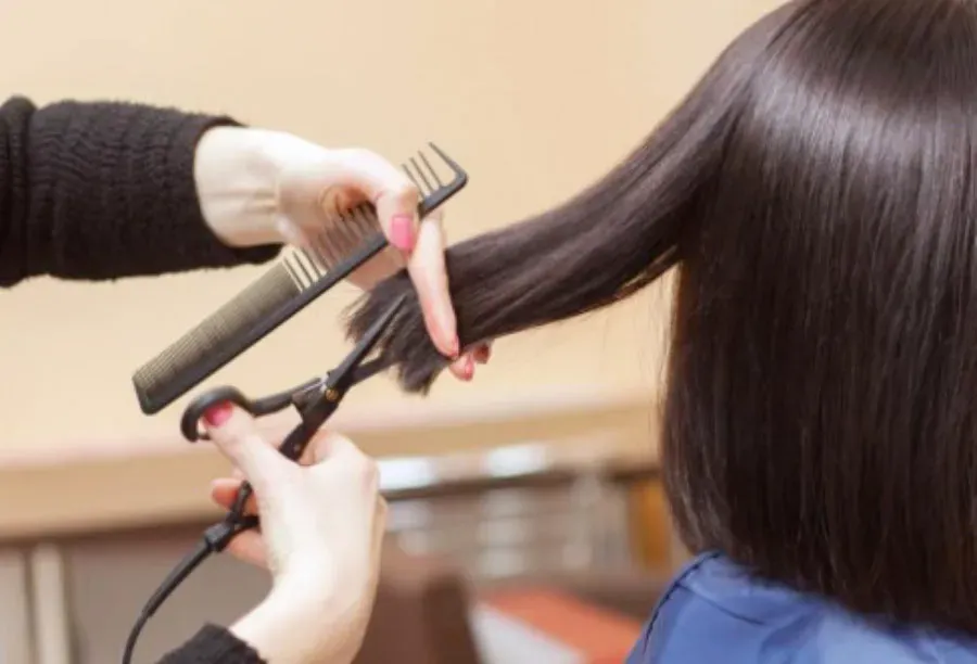 Thường xuyên cắt tỉa phần tóc chẻ ngọn là biện pháp quan trọng để ngăn hư tổn lan lên và kích thích sự phát triển của tóc mới