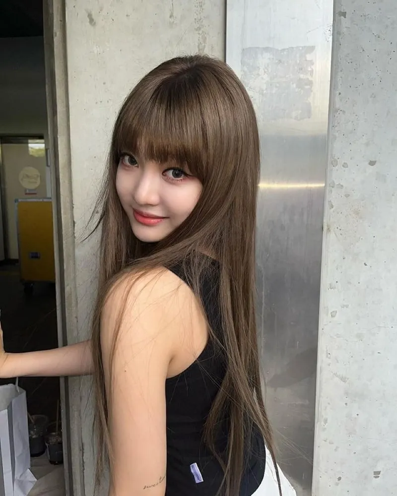 Người phụ nữ đang thực hiện liệu trình ép tóc bằng tinh dầu nóng, giúp tóc thẳng mượt tự nhiên