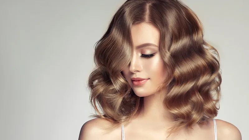 Thợ làm tóc chuyên nghiệp đang thực hiện kỹ thuật uốn tóc tẩy