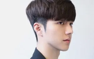 Soi gương và cân chỉnh toàn bộ mái tóc sau khi tự cắt tóc nam bằng kéo để đảm bảo đối xứng