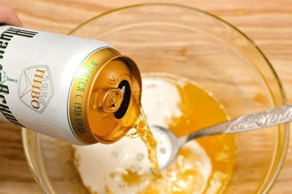 Một người phụ nữ đang ủ tóc bằng khăn ấm, minh họa kỹ thuật quan trọng trong cách dùng bia ủ tóc để tăng cường hiệu quả.