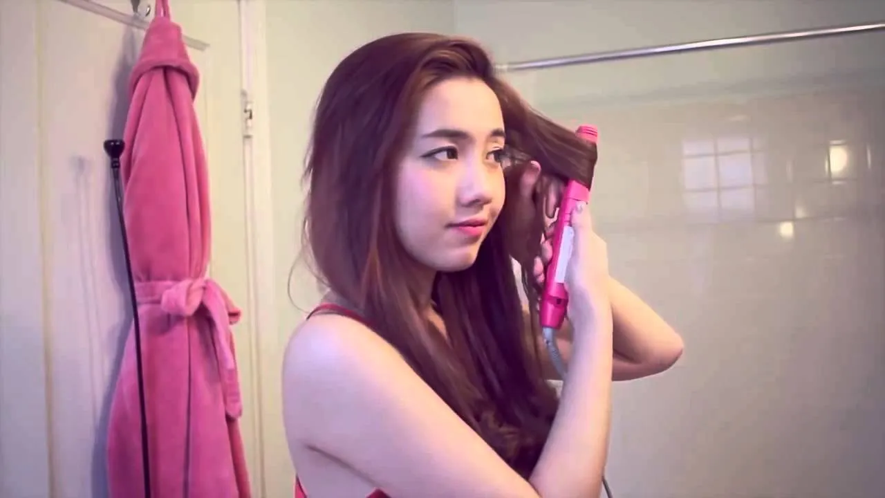 Người thợ làm tóc đang sử dụng máy uốn để tạo kiểu tóc giả đúng cách, kiểm soát nhiệt độ cẩn thận